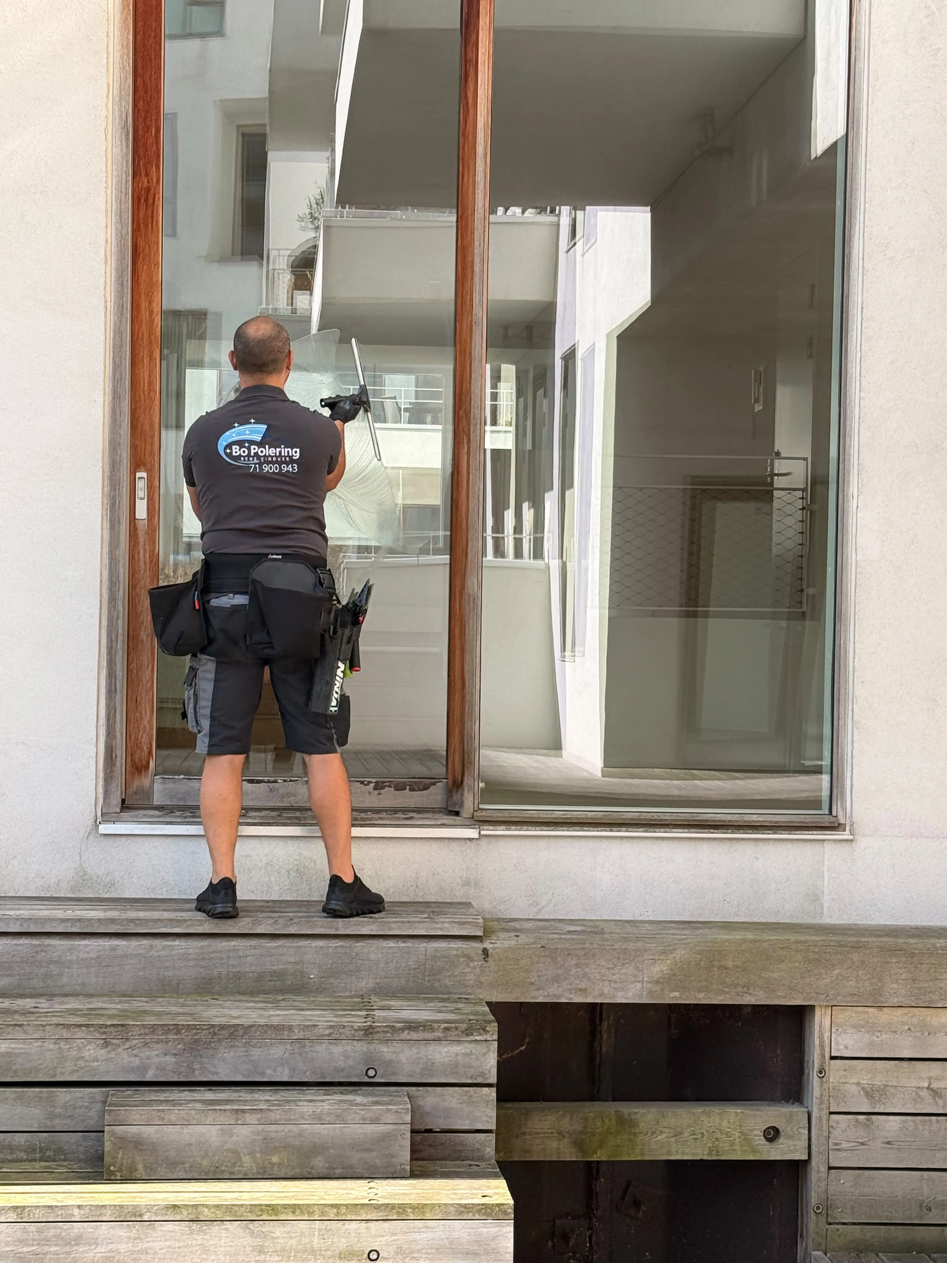 Bo Polering pudser et stort vinduesparti på Frederiksberg